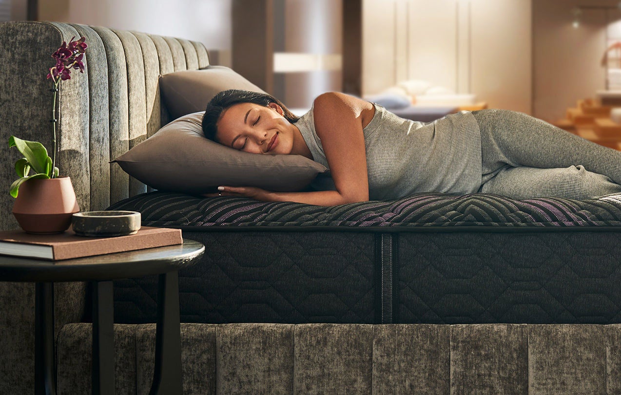 Woman sleeping on modern mattress in cozy room